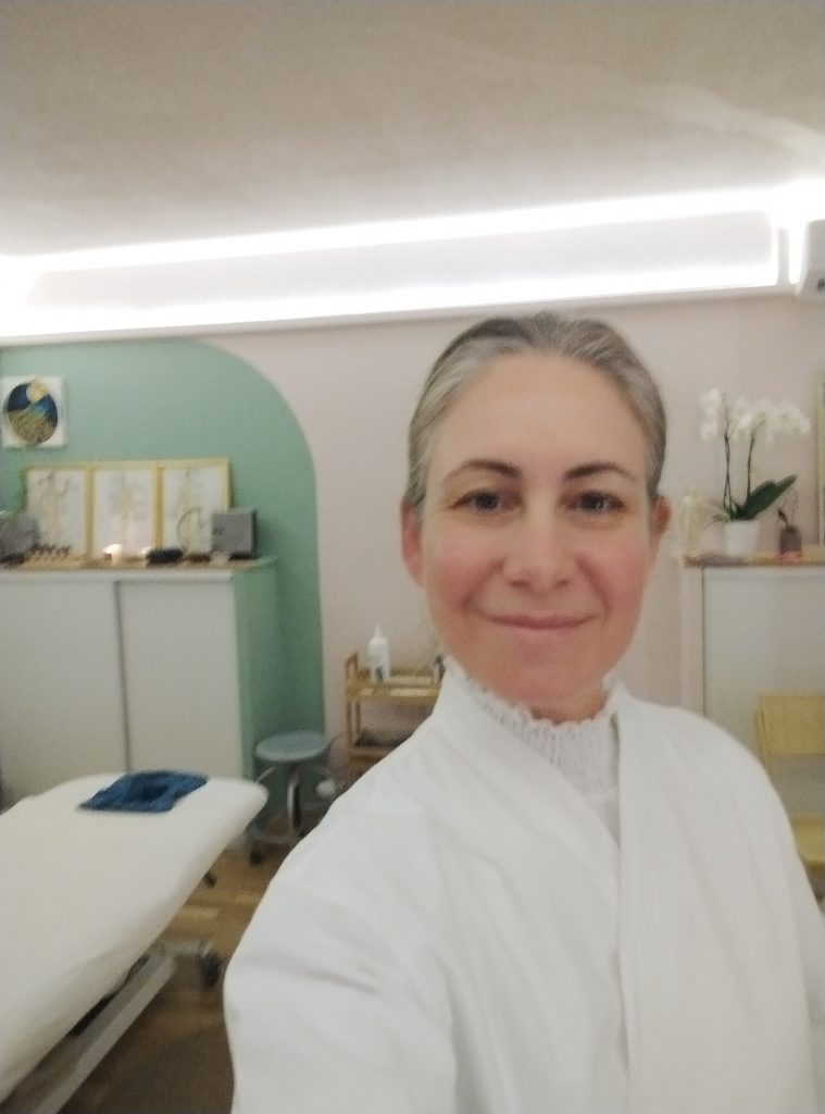 Amandine posant devant sa table de soin souriante